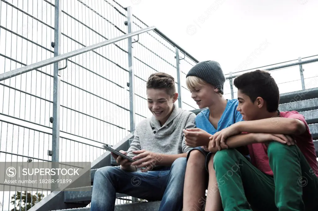 Boys with Tablet Sitting on Bleachers, Mannheim, Baden-Wurttemberg, Germany