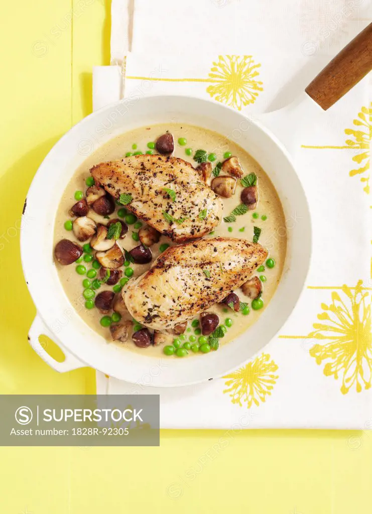 Overhead View of Chicken Breasts with Peas and Mushrooms in Cream Sauce in Skillet
