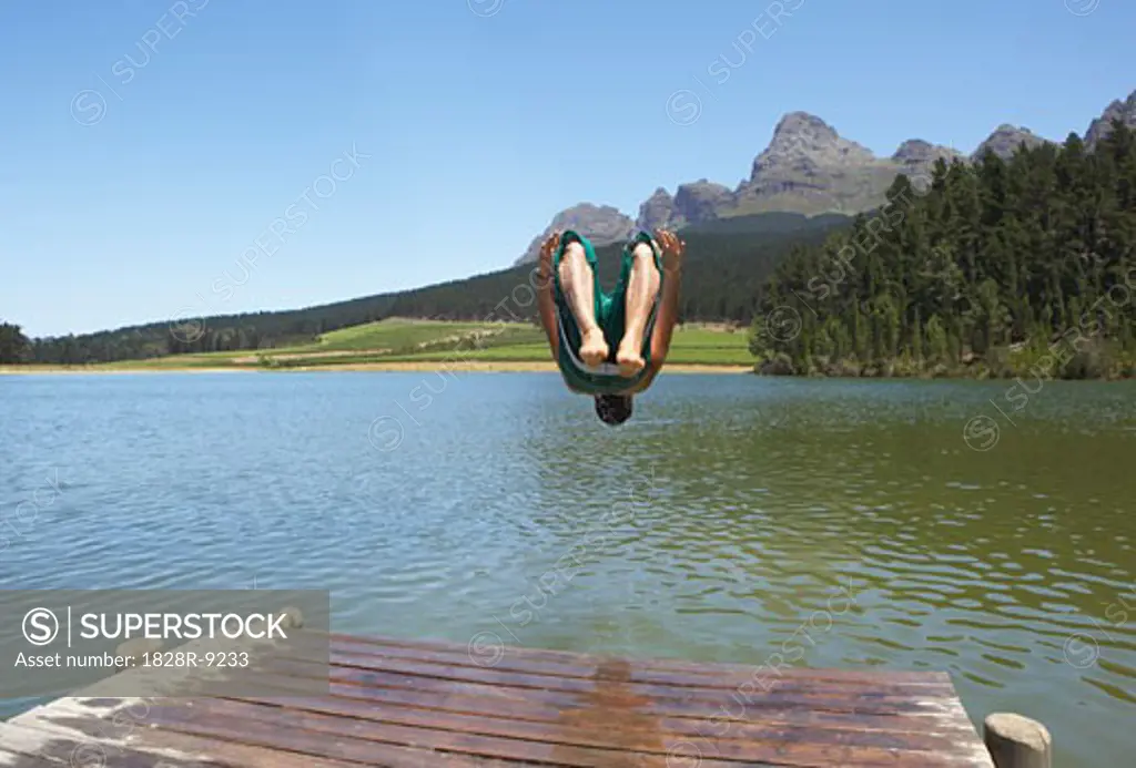 Man Jumping into Water from Dock   