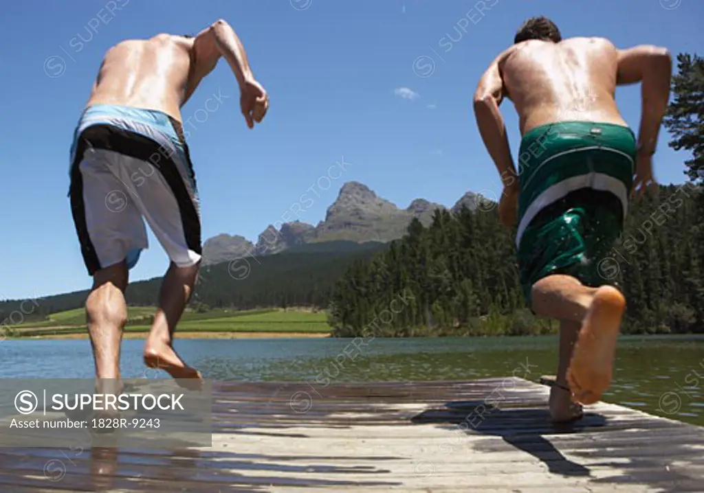 Men Jumping into Water from Dock   