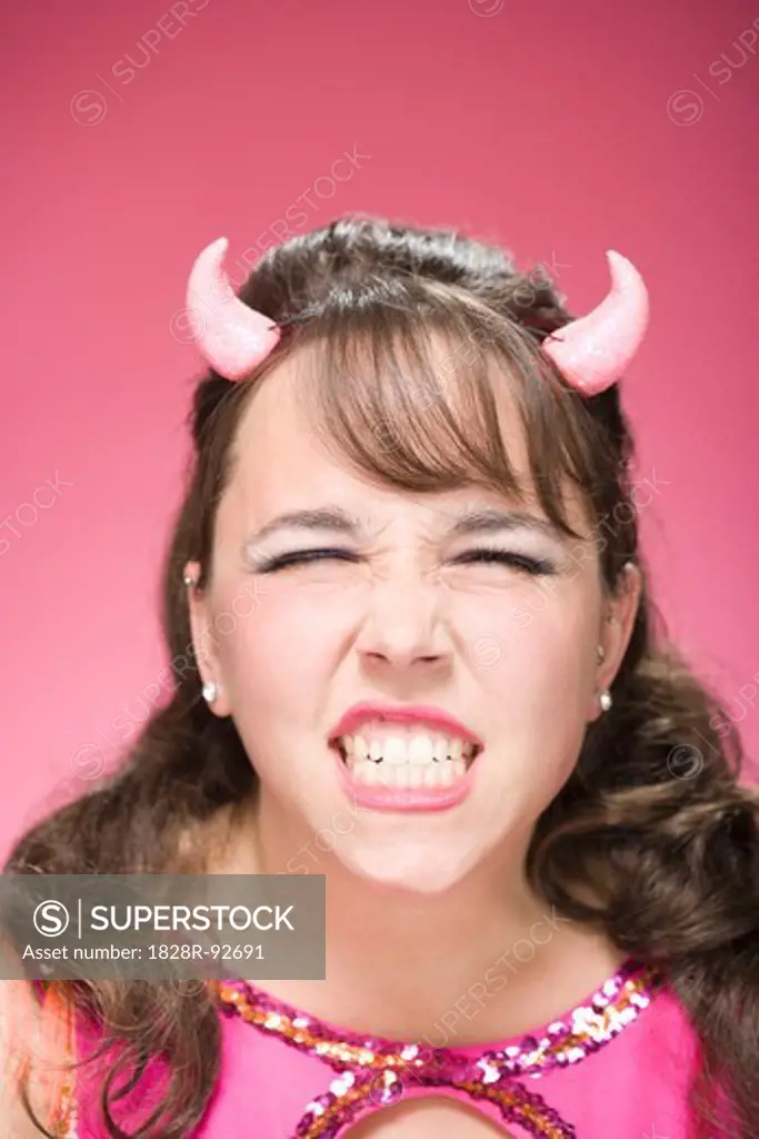 Portrait of Woman Wearing Devil Horns and Scowling