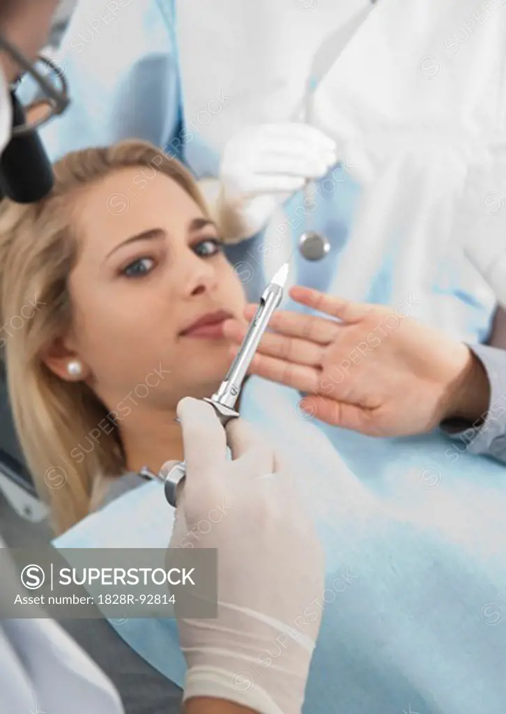 Young Woman declining Needle at Dentist's Office during Appointment, Germany