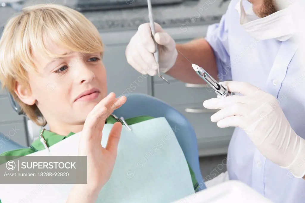 Boy declining Needle at Dentist's Office during Appointment, Germany