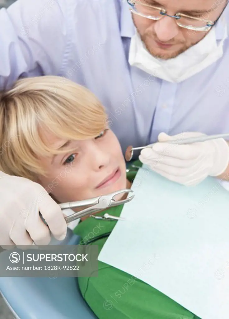 Anxious Boy looking at Dental Instruments during Appointment, Germany