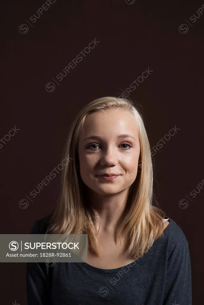 Portrait of Blond, Teenage Girl, Smiling at Camera, Studio Shot on Black Background