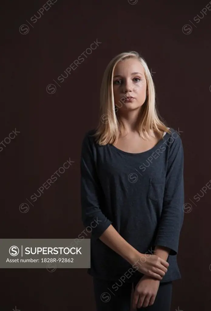 Portrait of Blond, Teenage Girl Looking at Camera, Studio Shot on Black Background