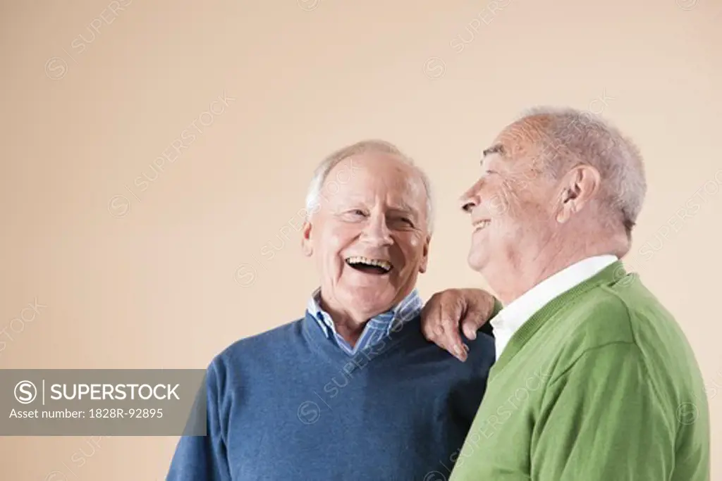 Portrait of Two Senior Men Laughing Together, Studio Shot on Beige Background