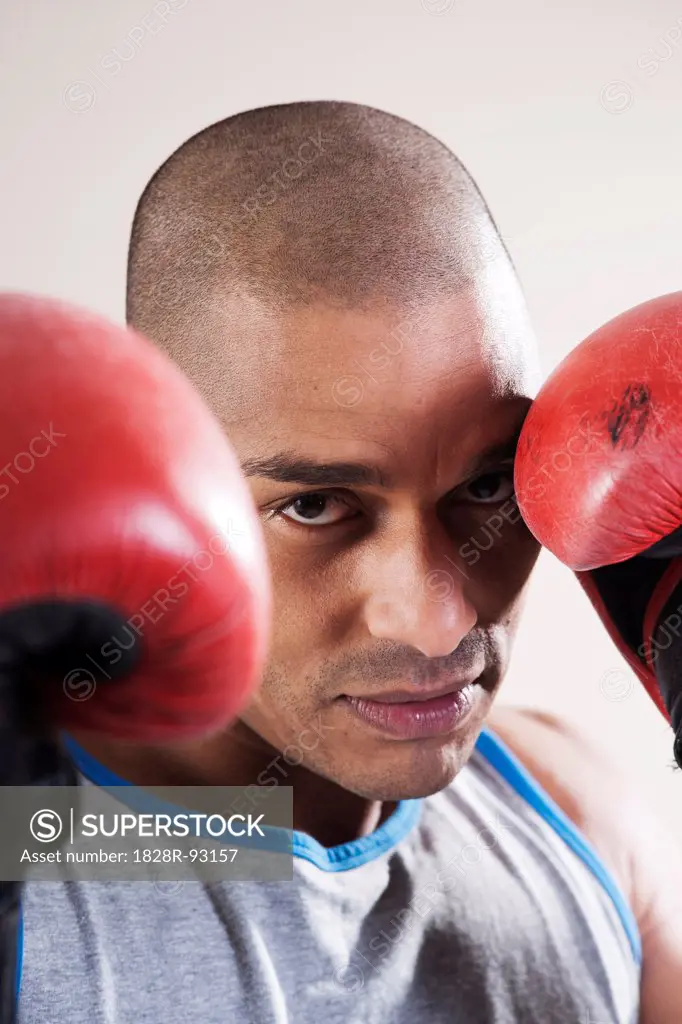 Man Wearing Boxing Gloves in Studio with White Background