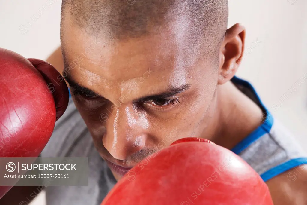 Man Wearing Boxing Gloves in Studio with White Background