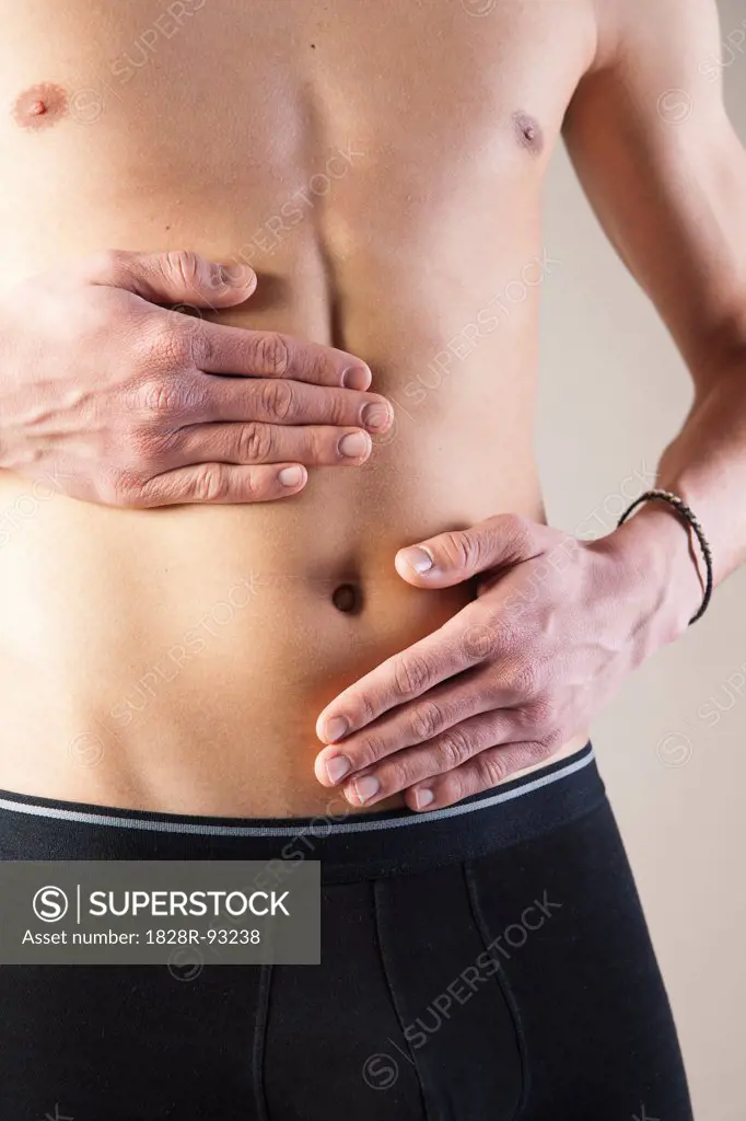 Close-up of Young Man in Boxer Briefs Touching Stomach in Studio