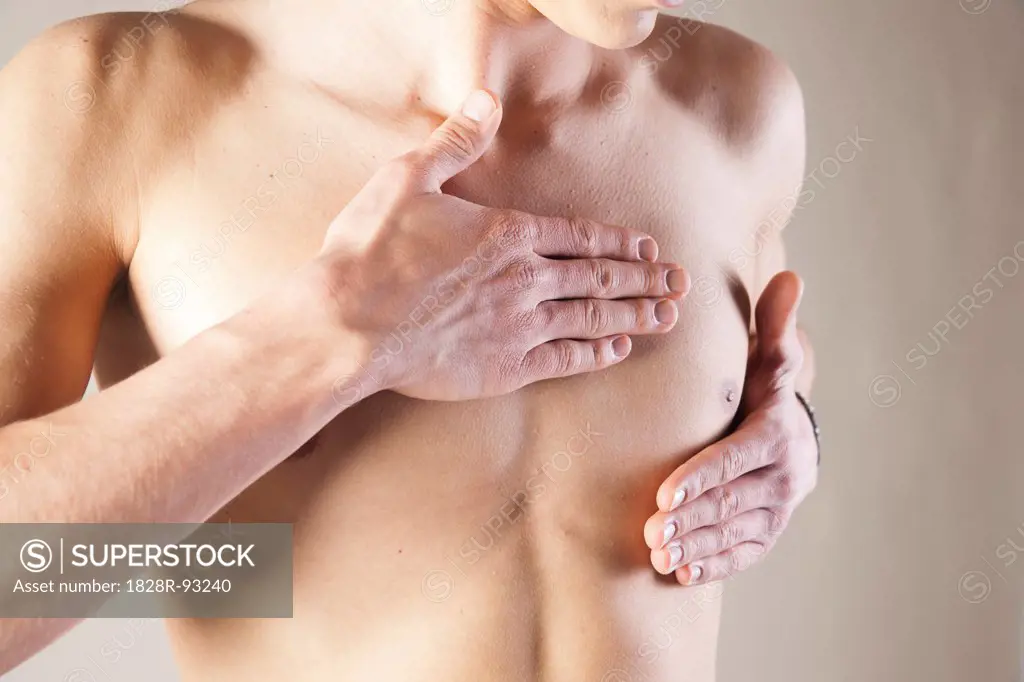 Close-up of Young Man Touching Chest in Studio