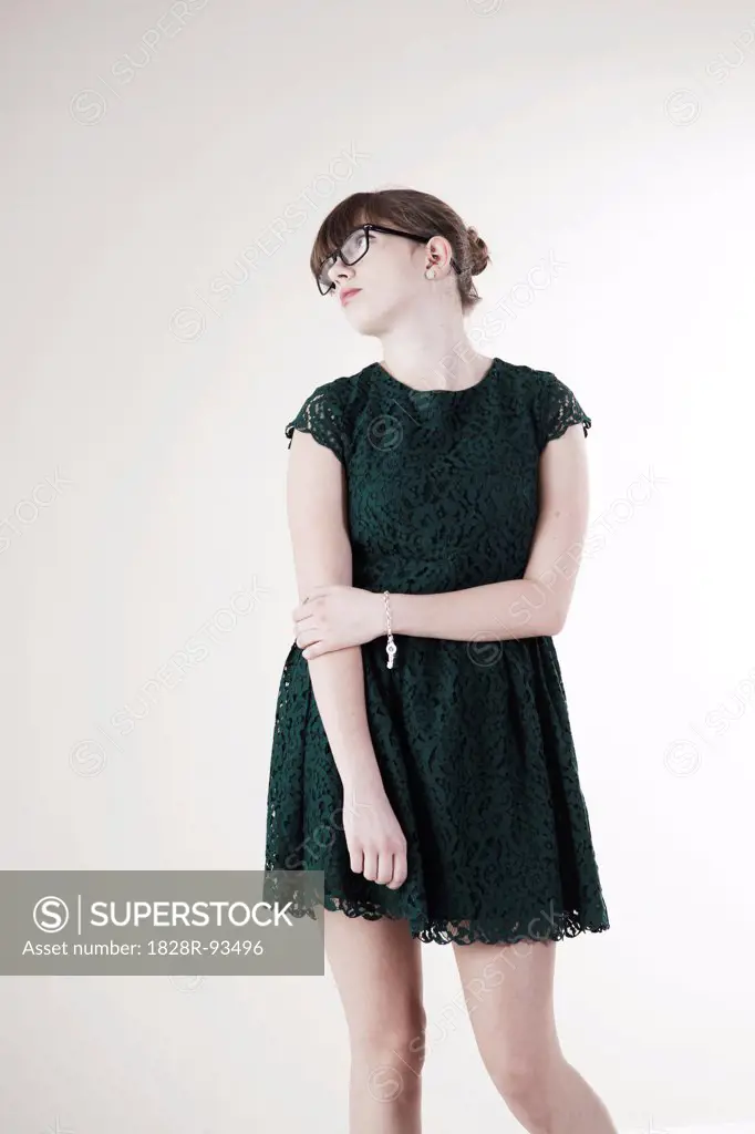 Portrait of Young Woman wearing Green, Lace Dress and Horn-rimmed Eyeglasses, Distracted and Looking Upward, Studio Shot on White Background