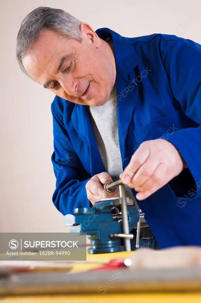 Man Filing a Pipe for a Plumbing Project, in Studio