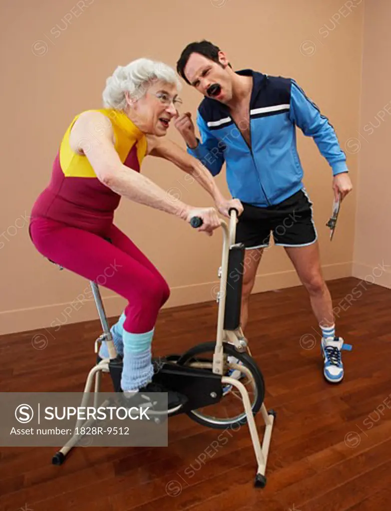 Personal Trainer Encouraging Woman on Exercise Bike   