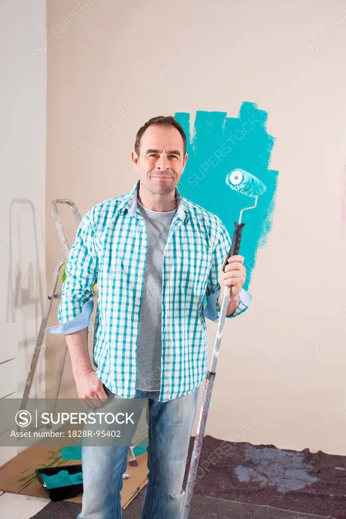 Mature Man Renovating his Home by Painting the Walls