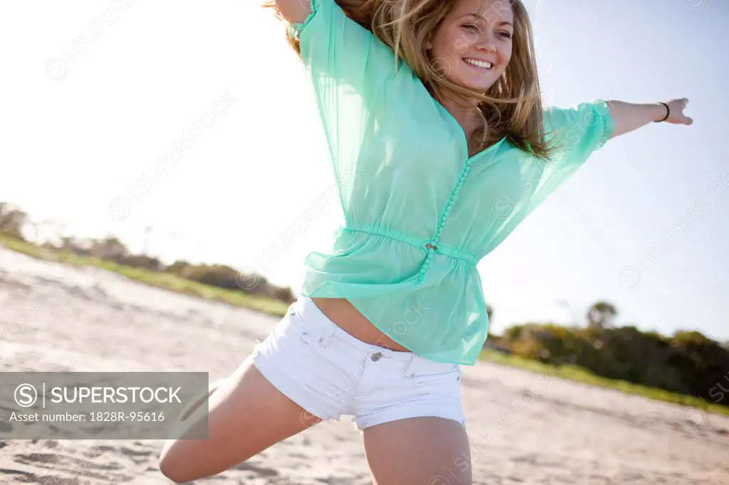 Young Woman Smiling and Jumping on Beach, Palm Beach Gardens, Palm Beach County, Florida, USA,03/06/2013