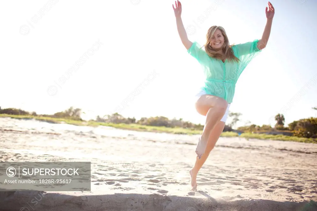 Young Woman Smiling and Jumping on Beach, Palm Beach Gardens, Palm Beach County, Florida, USA,03/06/2013