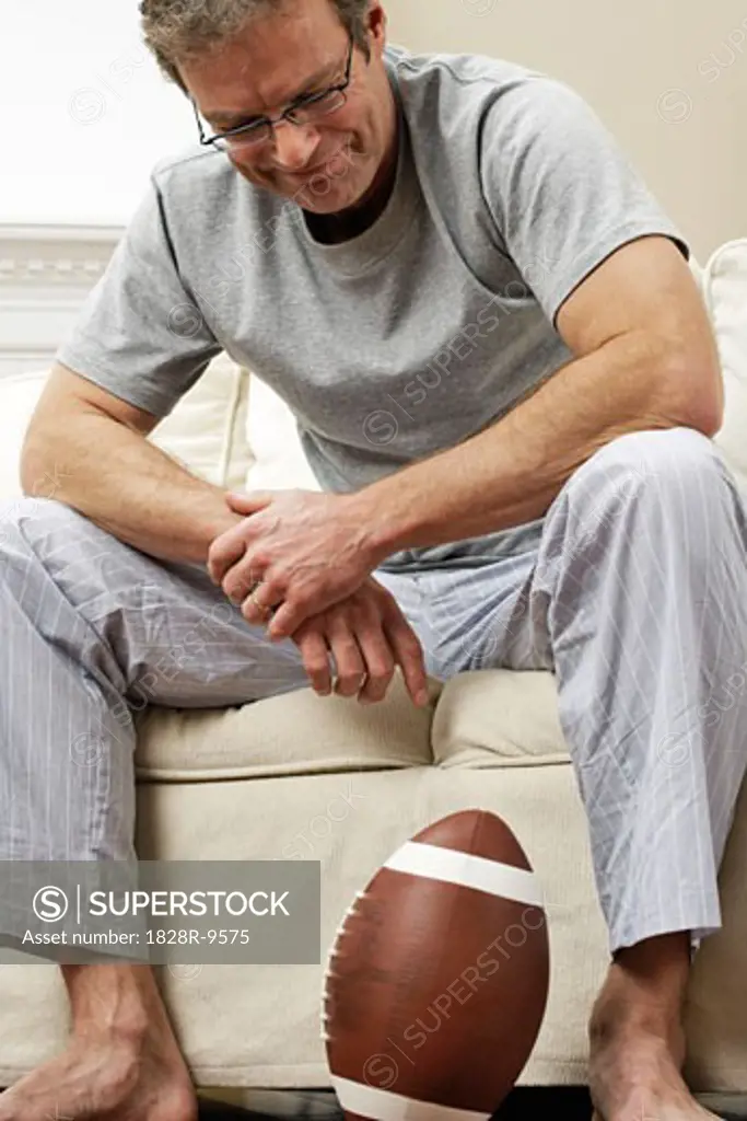 Man on Sofa with Football   