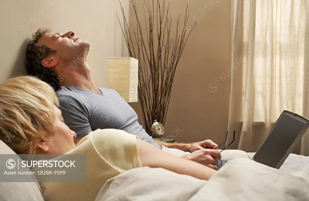 Couple with Laptop in Bed   