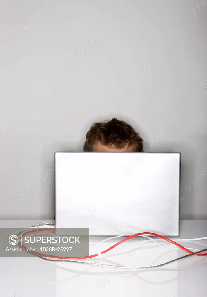 Man hiding behind laptop,02/29/2008