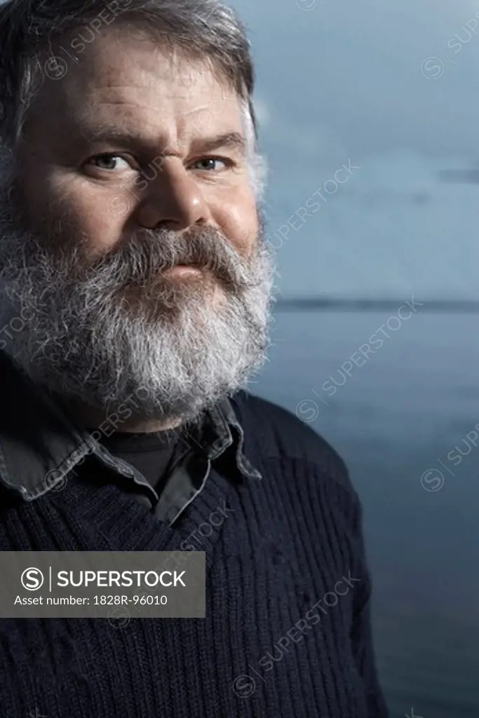 A portrait of a fisherman with gray beard on his boat on a winter day, Iceland,01/29/2007