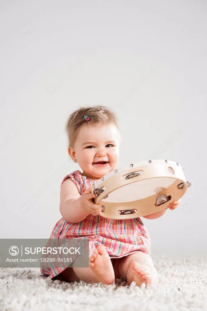 Portrait of Baby Girl holding Tambourine, Studio Shot,04/26/2013