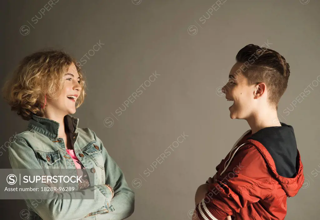 Teenage Boy and Girl looking at Each Other and Laughing, Studio Shot,04/28/2013