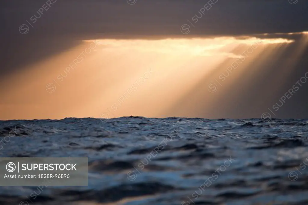 Sun rays shine through clouds casting beams of light after a storm in the Atlantic Ocean,12/06/2011