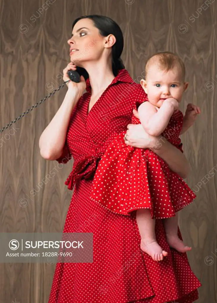 Woman Holding Baby While Using Telephone   