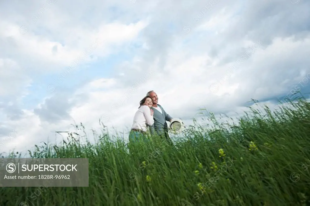Mature couple walking in field of grass, Germany,05/11/2013