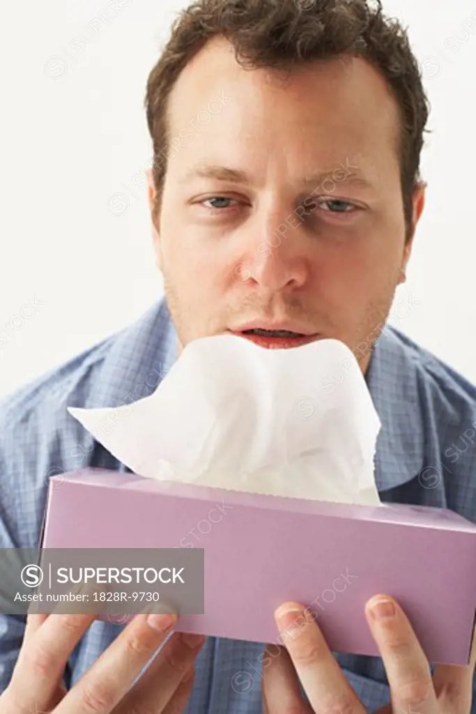 Sick Man Holding Tissue Box   