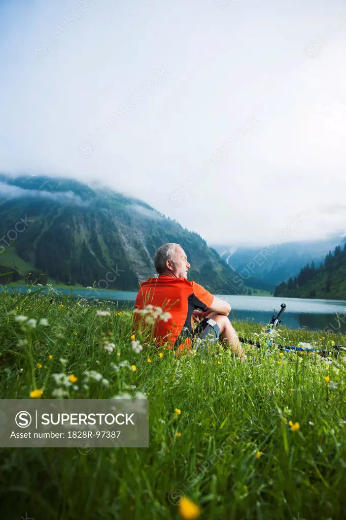 Mature Man with Mountain Bike sitting by Lake, Vilsalpsee, Tannheim Valley, Tyrol, Austria,06/14/2013