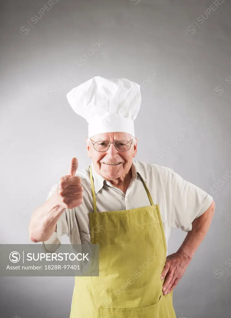 Senior Man in Apron and Chef's Hat giving Thumbs Up, Studio Shot,06/04/2013