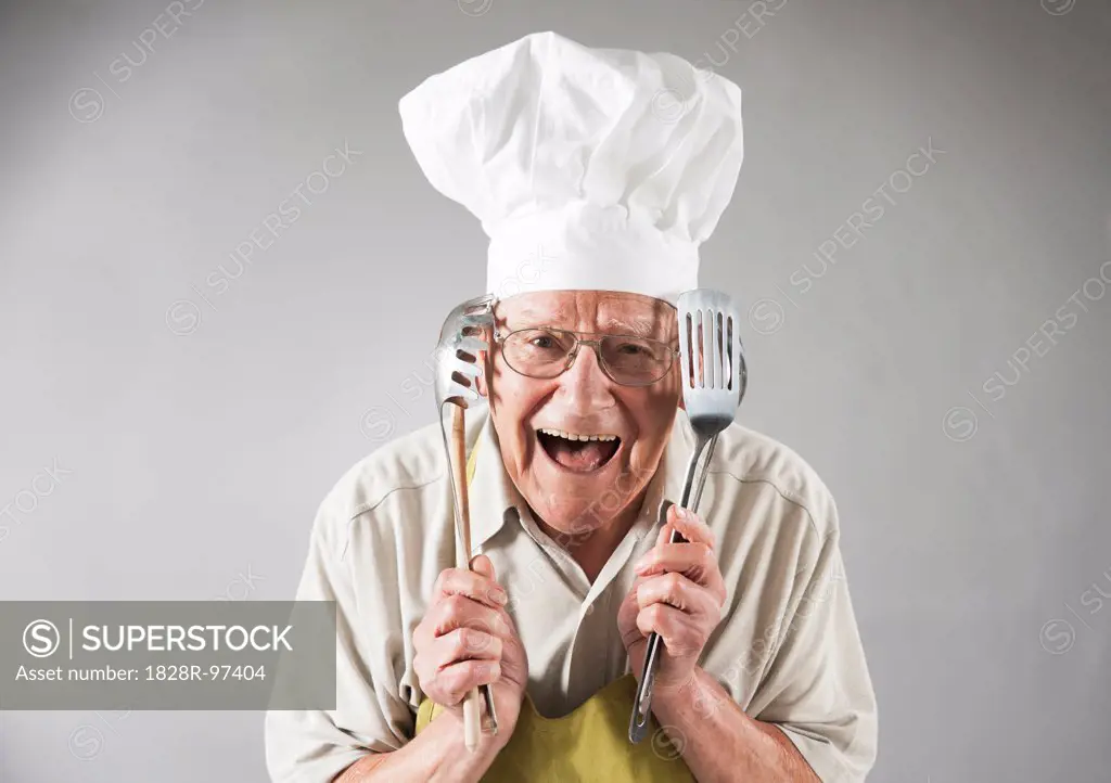Senior Man with Cooking Utensils wearing Apron and Chef's Hat, Studio Shot,06/04/2013