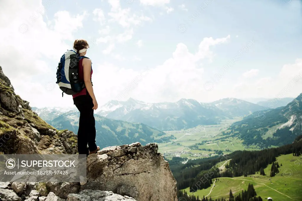 Mature woman standing on cliff, hiking in mountains, Tannheim Valley, Austria,06/15/2013