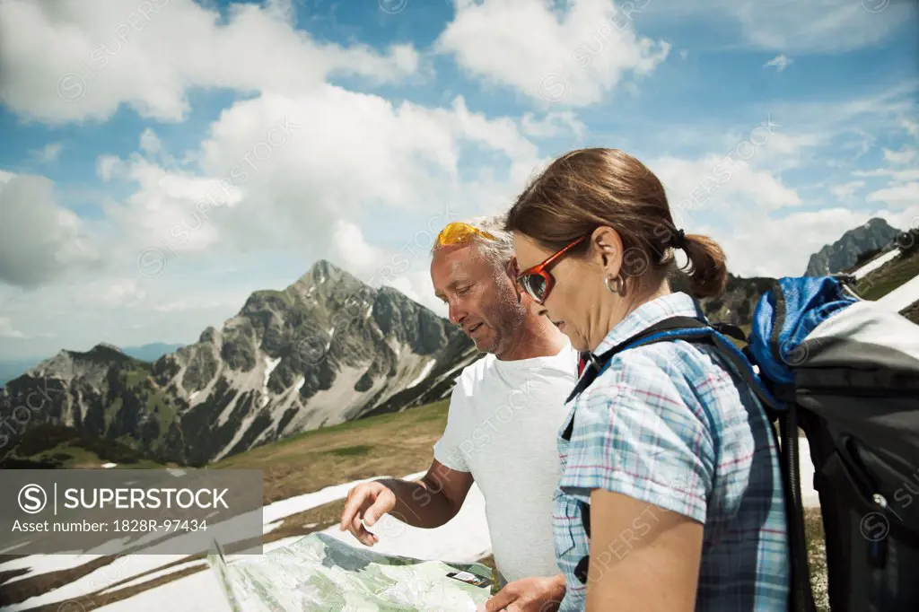 Mature couple looking at map, hiking in mountains, Tannheim Valley, Austria,06/15/2013