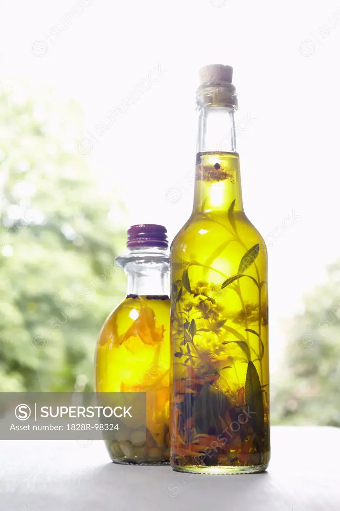 Still life of bottles of olive oil with herbs on window sill, Germany,07/29/2013