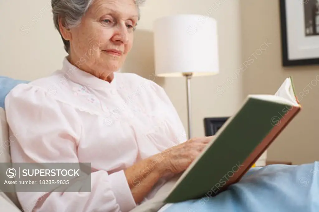 Woman Reading Book in Bed   