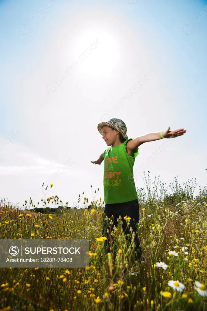 Girl standing in field with arms outstretched, Germany,07/19/2013