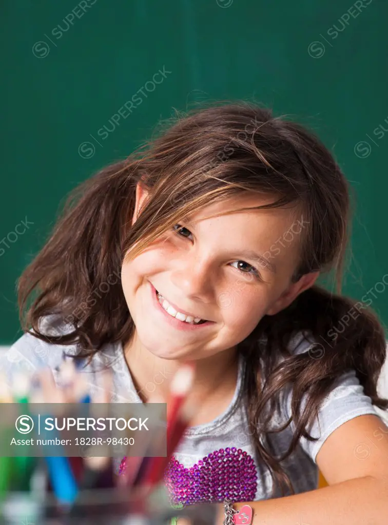 Close-up portrait of girl sitting at desk in classroom, Germany,07/24/2013