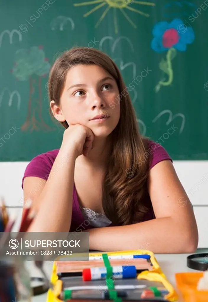 Teenaged girl sitting at desk in classroom, Germany,07/24/2013