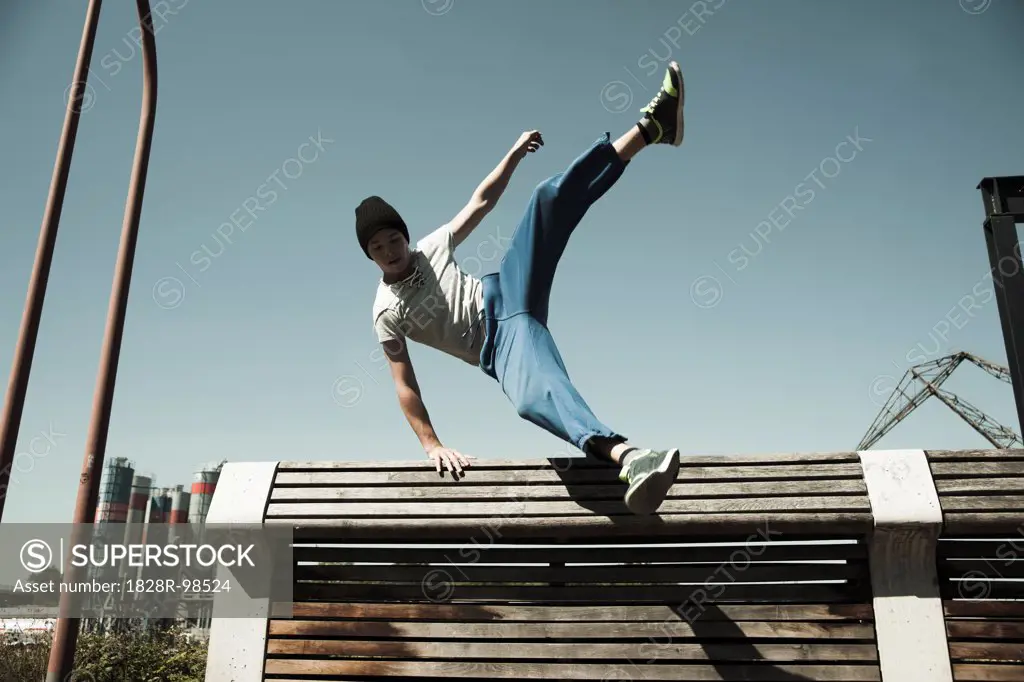 Teenaged boy jumping over barrier, freerunning, Germany,08/16/2013