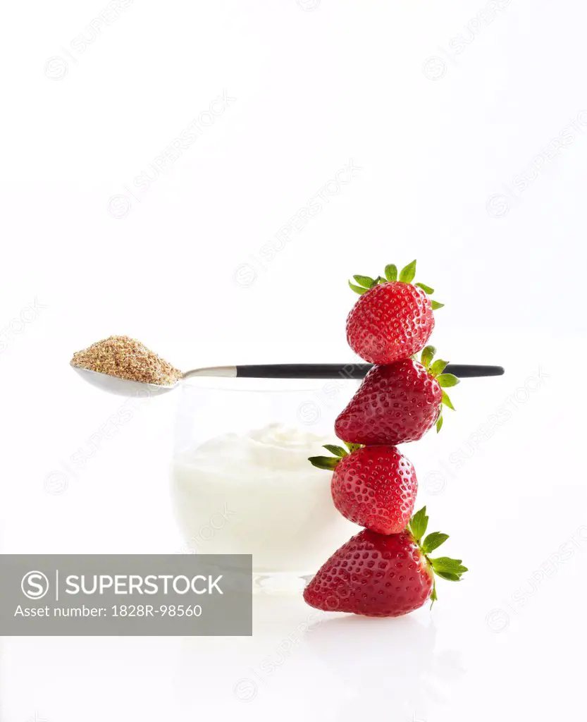 Stack of Fresh Strawberries, Glass of Greek Yogurt and Spoon of Ground Flax Seeds, Studio Shot,03/21/2011