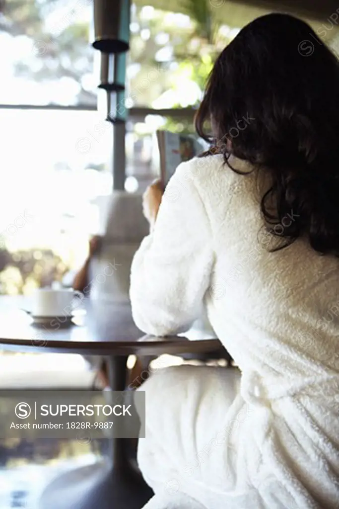 Woman Sitting At Kitchen Table   