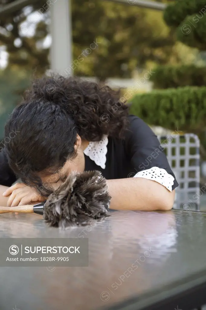 Maid Resting Head On Table Outdoors   