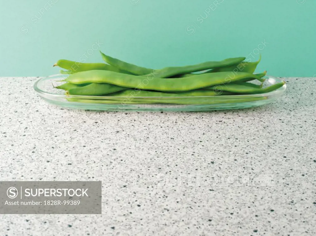 Raw, green, runner beans in glass dish on countertop, studio shot. 09/01/2013