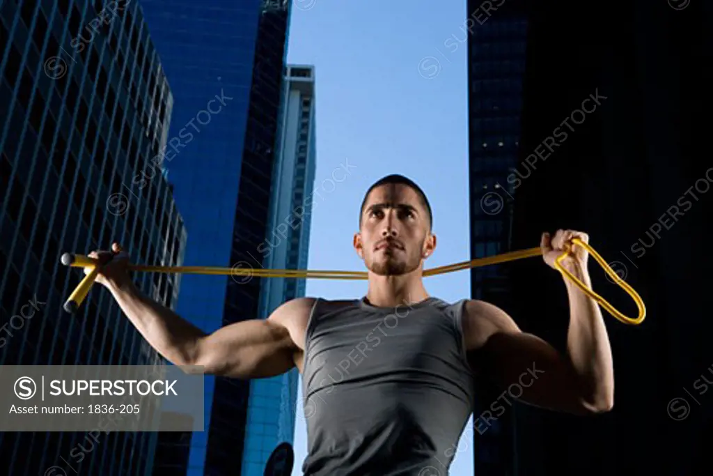 Low angle view of a young man holding a jump rope