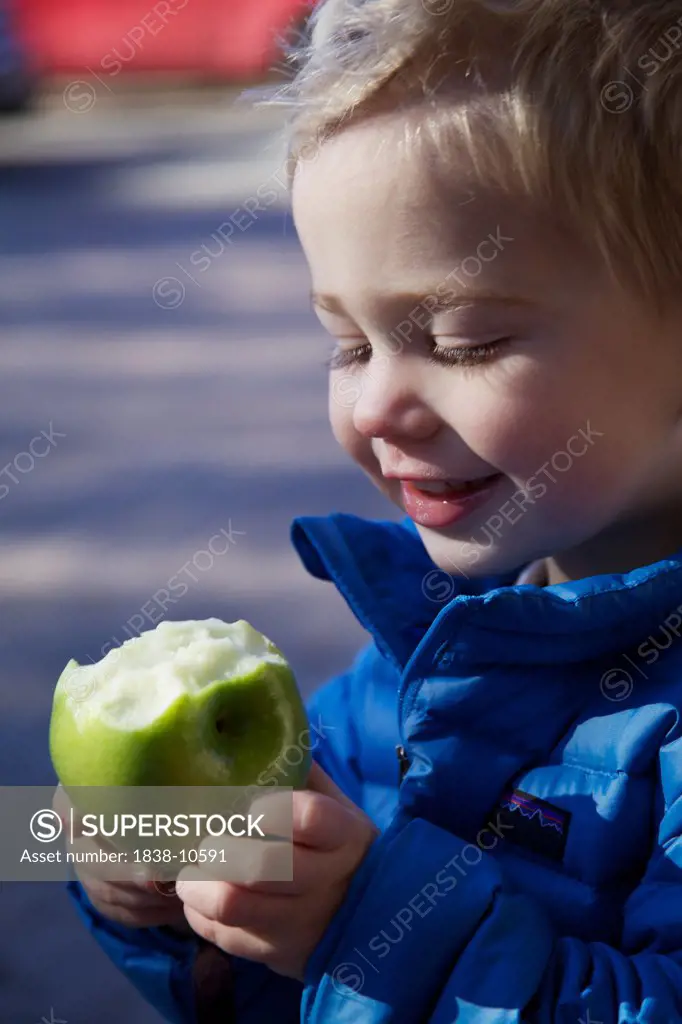 Smiling Boy Eating Green Apple