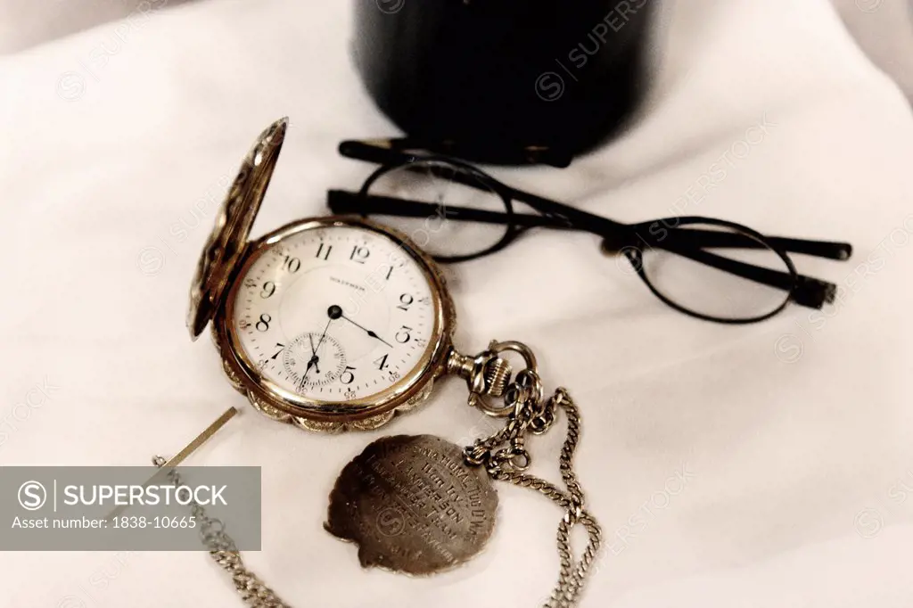 Pocket Watch and Eyeglasses With One Cracked Lens