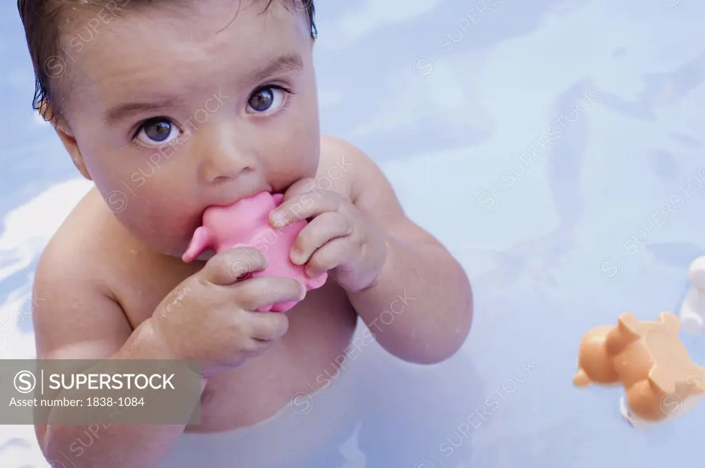 Baby Taking Bath with Plastic Toy in it's Mouth